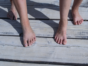 Füße auf einem hölzernen Pier