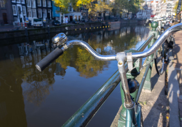 Amsterdam, ein Fahrrad, das am Geländer neben dem Kanal befestigt ist.