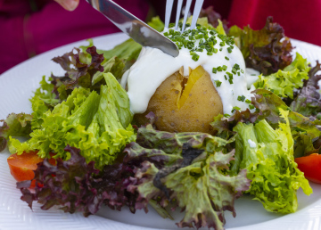 Ofenkartoffel und grüner Salat auf einem Teller