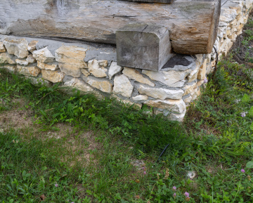 Steinfundament unter dem Holzgebäude