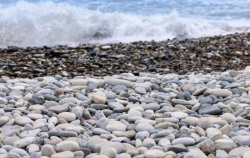 Steine am Strand und Meereswellen