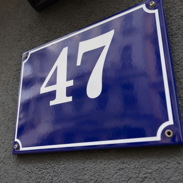 Hausnummer 47, blaue Plakette an der Gebäudefassade