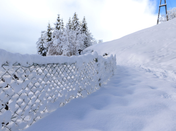 Starker Schneefall und ein begrabener Zaun.
