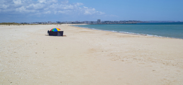 Ein Regenschirm an einem leeren Strand