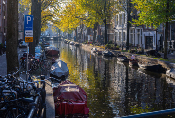 Kanal in Amsterdam und mit Planen bedeckte Boote