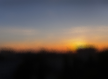 Sonnenuntergang durch das gefrostete Fensterglas