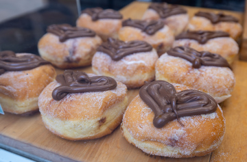 Mit Füllung gefüllte und mit Schokoladenherzen verzierte Donuts