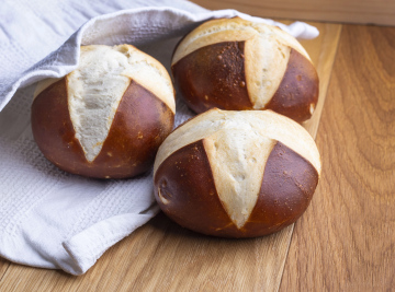 Drei frische Brötchen auf einer Holzplatte