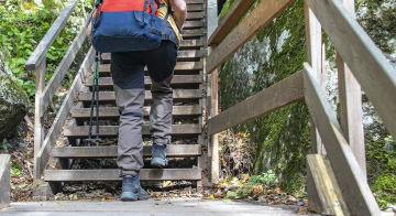 Tourist mit Rucksack auf Holztreppe