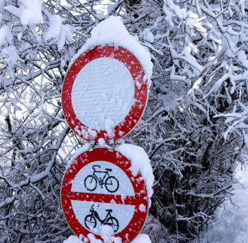 Schneefall. Kalter Winter und bedeckte Verkehrszeichen.