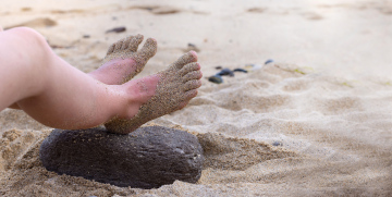 Füße am Strand stecken im Sand fest