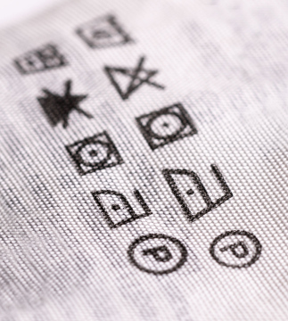 Ein Etikett auf dem Kleidungsstück mit Angabe der Wasch- und Bügelmethode