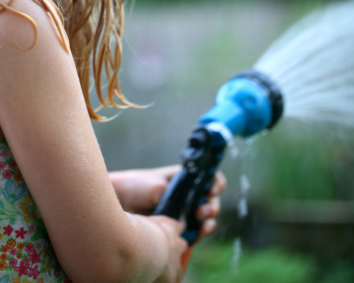 Wasser im Garten, gießen, Sprinkler in der Hand