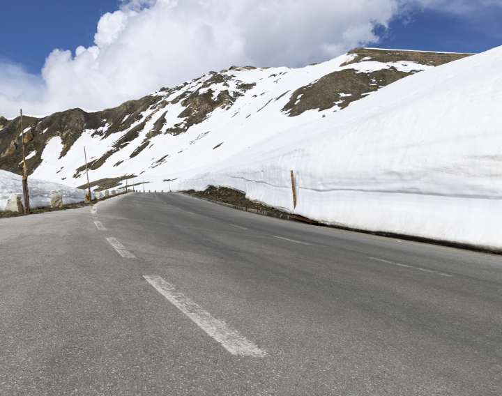 Asphaltstraße und schneebedeckte Berge