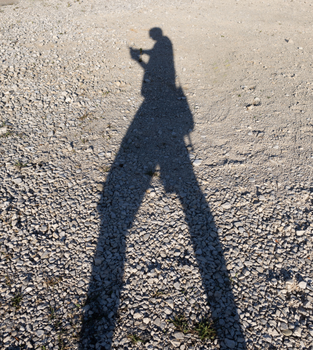 Mann mit Telefon, langer Schatten