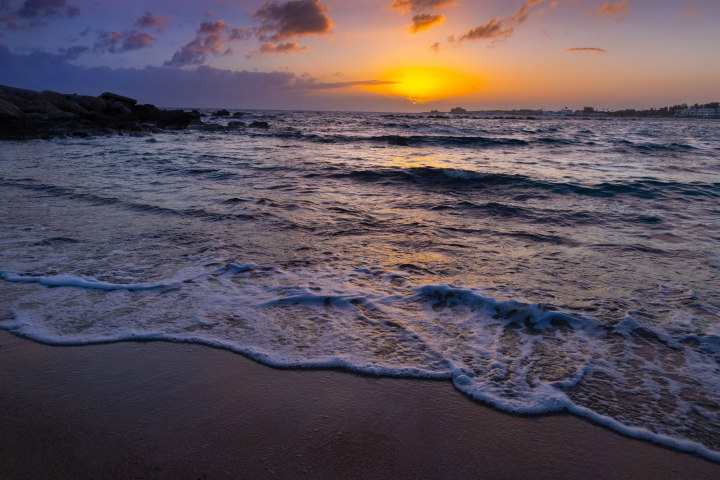 Sonnenuntergang und Wellen am Strand