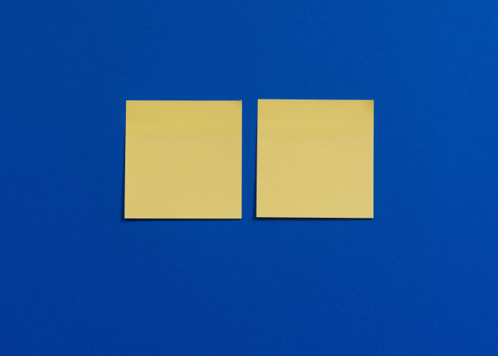 Zwei gelbe Haftnotizen auf blauem Hintergrund