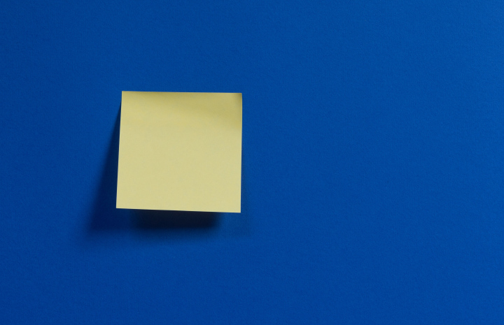 Quadratischer gelber Zettel auf blauem Grund