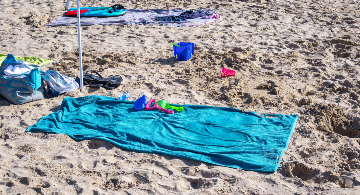 Türkisfarbenes Handtuch am Sandstrand