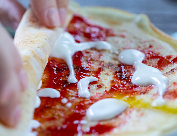 Gerollter Pfannkuchen mit Marmelade und Joghurt