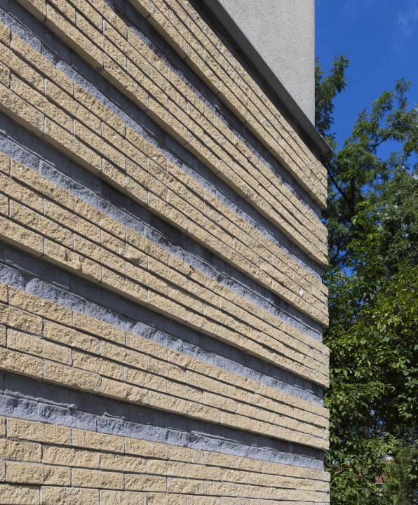 Seitenfassade des Gebäudes mit einem Muster, das einen Ziegelstein imitiert