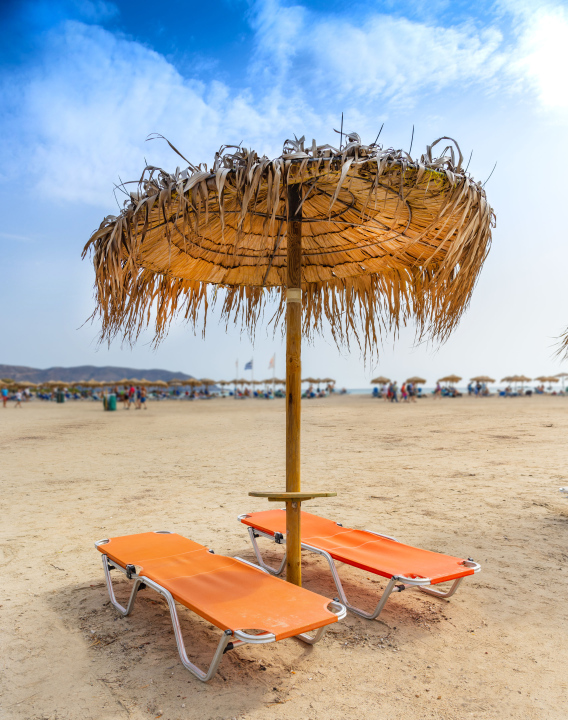 Leere Liegestühle und ein Schilfschirm