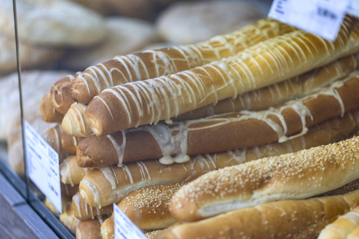 Brot im Angebot. Lange Brötchen mit geschmolzenem Käse und mit Sesam bestreut.